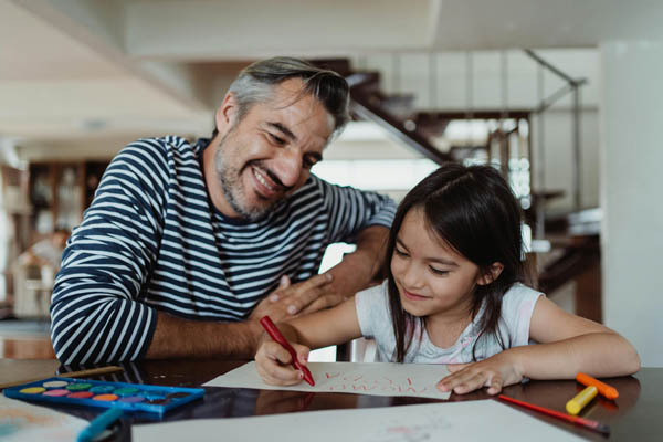 Dad and daughter coloring at a clean table after summer house cleaning in manassas